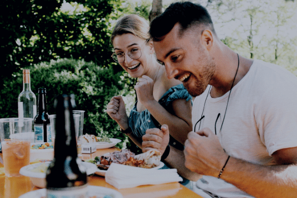 Two people enjoying a meal during a summer party